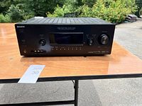Front view of Sony receiver showing input selector knob, volume knob, headphone jack, and front audio inputs.