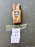Brown Southwire T200K tone generator device placed on gray surface with lot tag number 70 taped beside it.