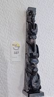 Overall front view of 17" tall black argillite totem on white background with lot number card visible