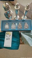 Photo showing the three sterling silver shakers, the blue box with glass shakers, and two teal Birks polishing cloth bags