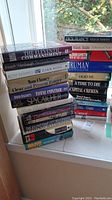 Stack of assorted hardcover books showing an overview including titles like The Eleventh Commandment, Harm Done, Clear and Present Danger and more
