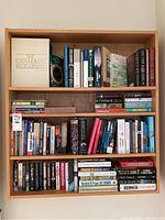 Books on wooden shelf, including The Canadian Encyclopedia and several fiction/non-fiction titles.