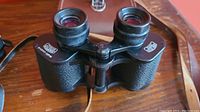 Front view of black Carl Zeiss 8x30 binoculars with textured grip and eyepiece lenses.