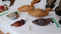 Top view of all five carved wooden ducks together showing size variation and finishes.