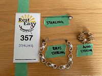Overview of three sterling silver items with green labels reading 'STERLING', 'BIRKS STERLING', and 'AVON STERLING' alongside a penny for size reference.