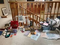Full view of sewing supplies lot with thread organizer, baskets with fabric and accessories, scissors, and paper patterns spread on floor.