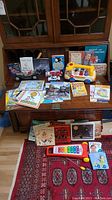 Overview of all items including books, toys, toy vehicles, and a xylophone on a wooden cabinet and a carpeted floor.