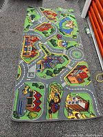 Photo showing full view of a rectangular children's play carpet with colorful roads and city designs.