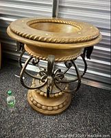 Photo of the ornate designer table base showing rope detail and black metal decorative scrolling supports.