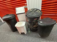 Six assorted garbage bins in various sizes and materials, shown together with some dust and minor stains.