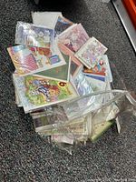 Overview of assorted greeting cards in plastic packaging, showing various colorful designs including animals and florals.