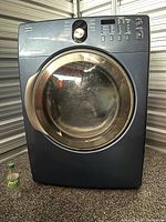 Front view of Kenmore blue metallic front load dryer with digital control panel and large transparent door.