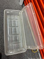 Open view of plastic storage box with lid beside it showing interior and bottom ribs.