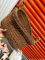 Photo of woven wooden basket angled to show the exterior and one handle.