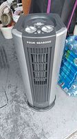 Full view of the tower appliance showing front grille, brand 'Four Seasons', and general color and shape.
