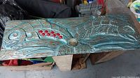 Full front view of entire carved plaque showing two salmon, turquoise finish, red beads and shell inlays