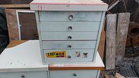 Front view of wooden tool cabinet with four drawers, light blue with stickers and decals