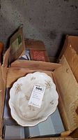 Photo of stacked Johann Haviland Bavaria china bowls with floral patterns, placed inside a box with other items.