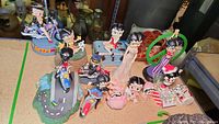 Photo of multiple Betty Boop figures on a table including ones on motorcycles and in standing, dancing, and sitting poses.