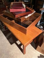 Wood coffee table with display cases and photo albums stacked on top, showing wood finish and glass tops.