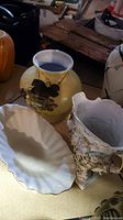 Lenox footed bowl, one floral vase, and fluted porcelain dish seen from top angle on base surface.