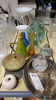 Various vases, metal trinket boxes, serving tray and decorative items on table.