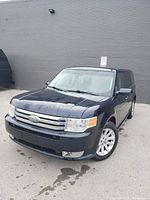 Exterior front three-quarter view showing blue metallic paint, chrome grille and alloy wheels
