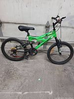 Side profile image of green and black Momentum Supercycle full suspension mountain bike. Shows frame, wheels, saddle, pedals, and gears.