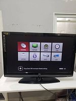 Front view of the black LG flat-screen TV showing the settings menu on the screen with various options like channel, picture, audio, and USB.