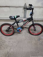 Side view of black Illusion Supercycle BMX bike with red rims and 13-inch wheels showing overall condition and design.