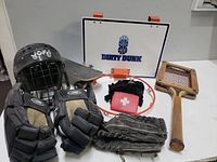 Photo showing overall lot of sports equipment including basketball hoop, hockey gloves and helmet, old tennis racket, baseball glove, hand wraps