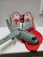 Photo showing both the grey plastic toy airplane and the basketball scoring game with two hoops.