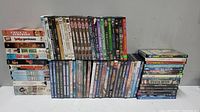 Photo showing overall collection of VHS tapes and DVDs arranged in three rows on the floor against a wall