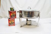 Chafing dish with visible frame, lid, and two boxes of cooking fuel beside it