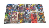 Top-down photo showing 15 different Superman comic books with colorful, detailed covers.