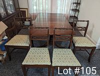 Photo showing full extended antique dining table with drop leaves and 4 matching chairs.