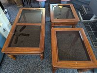 Top down view of the three tables showing glass tops and wooden frames