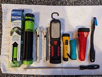 Flashlight assortment arranged on towel showing different types and packaging