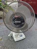Front view of the Classic oscillating fan showing metal guard, missing back cover piece, and white plastic base with speed control buttons.