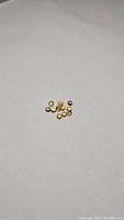 Parcel of 11 deep golden yellow round cut sapphires arranged loosely on white background.