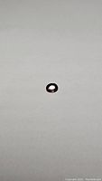 Single oval cut purple sapphire gemstone lying on white background showing facets and color