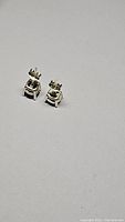 Pair of blue sapphire stud earrings in polished 925 sterling silver with butterfly backs shown from side angle
