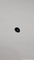 Single oval cabochon blue star sapphire stone shown on white background.