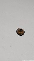 Top and side view of the round diamond cut smokey quartz gemstone on a white background.