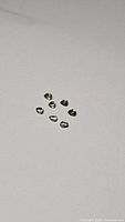 Seven natural mint green pear cut sapphires on plain white background showing color and clarity.