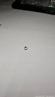 Photo of the round cut sky blue topaz gemstone on white background, showing its light blue color and clarity.