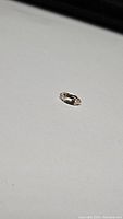 Close-up photo of a single marquis cut peach Morganite gemstone on a white background.