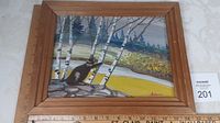 Full view of framed relief art showing beaver, birch trees, river, and forest.