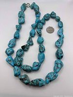 Necklace and bracelet laid flat with a quarter for scale showing bead size and set components