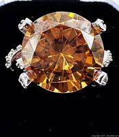 Top‐down close view of round orange sapphire in four-prong setting